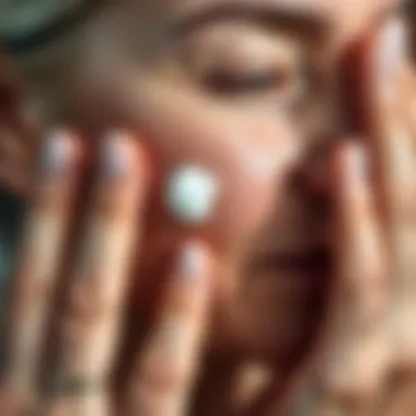 Close-up of a hand applying cream on aged skin